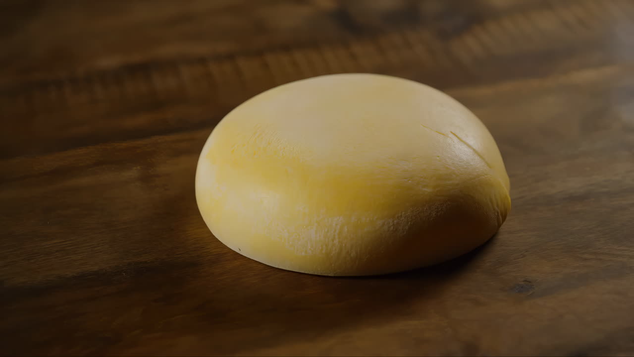 Round Block of Fresh Cheese on a Wooden Table
