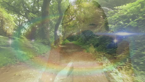 imagen compuesta de la llamarada del arco iris contra la mujer usando binoculares y camino del bosque