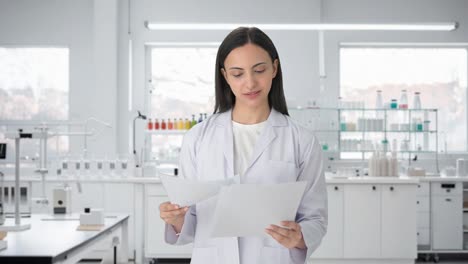 Happy-Indian-female-scientist-reading-reports