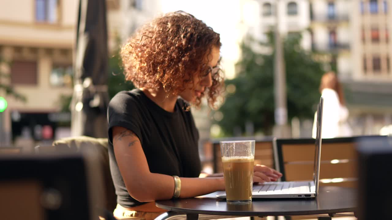 Donna che lavora al computer portatile al caffè