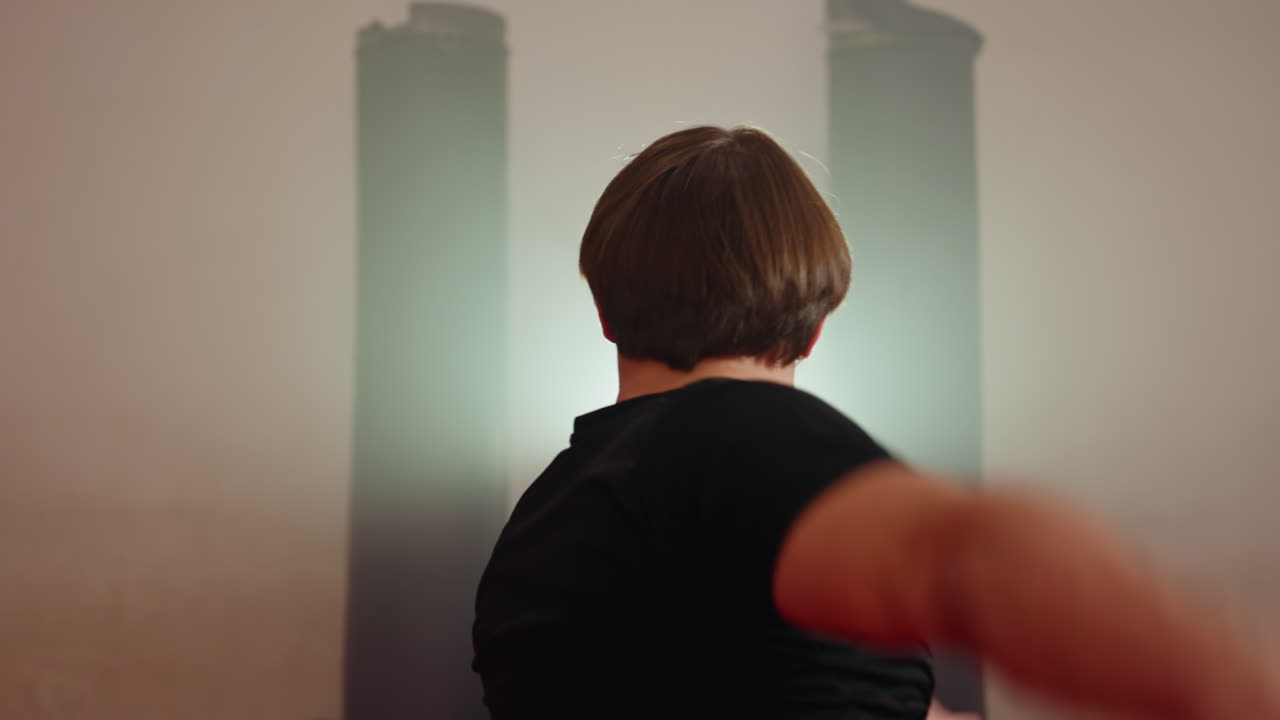 Karate practitioner executing acrobatic handstand kick during martial arts training in gym, legs extended high in dynamic motion, body control emphasized on red mats under spotlight with energy and discipline