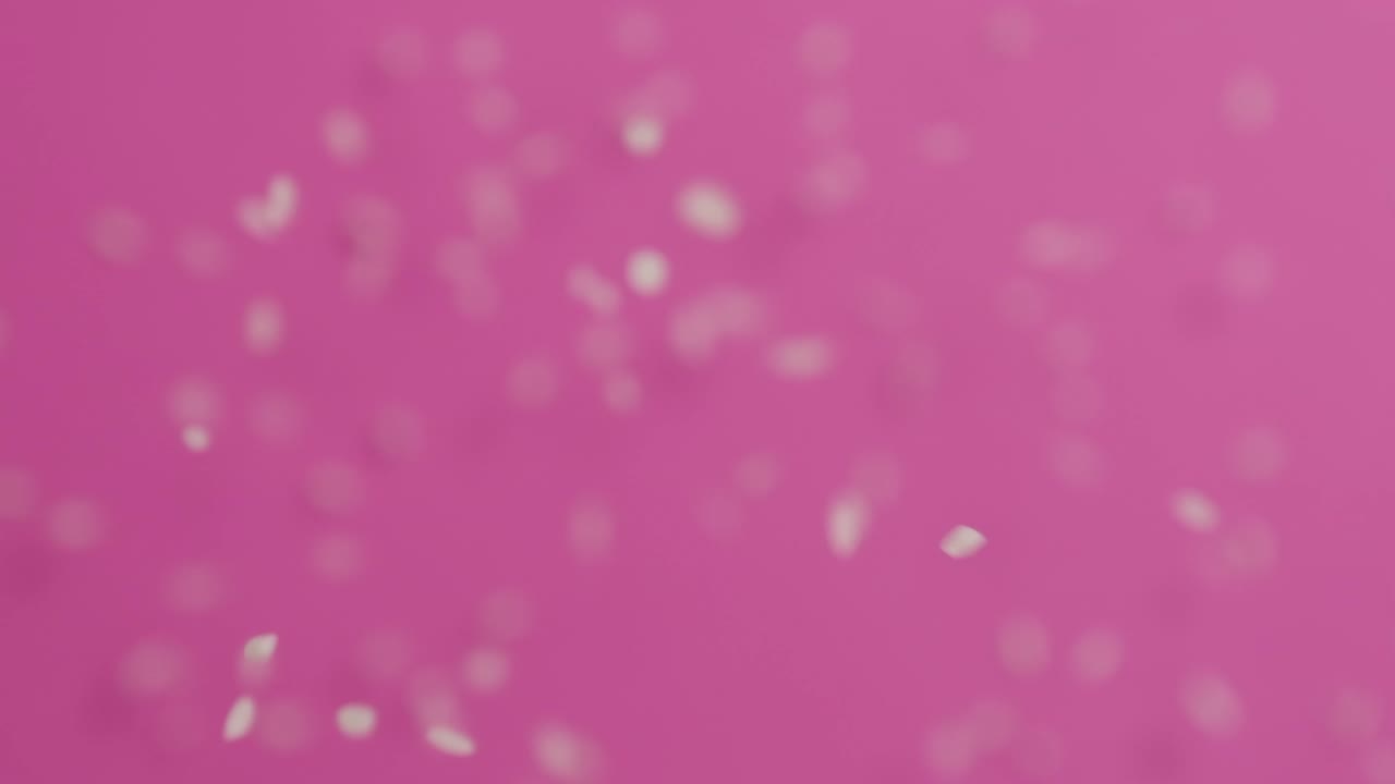 el arroz cayendo sobre un fondo rosado