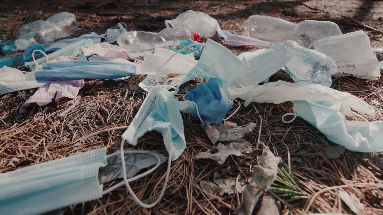 el viento sopla sobre un montón de basura con máscaras médicas