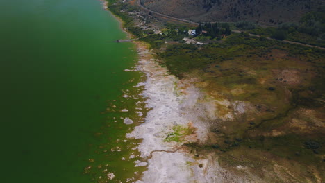 Beautiful scenery of Mono Lake, California, United States. White salty scurf on the waterfront verging with green grass and then mountain.