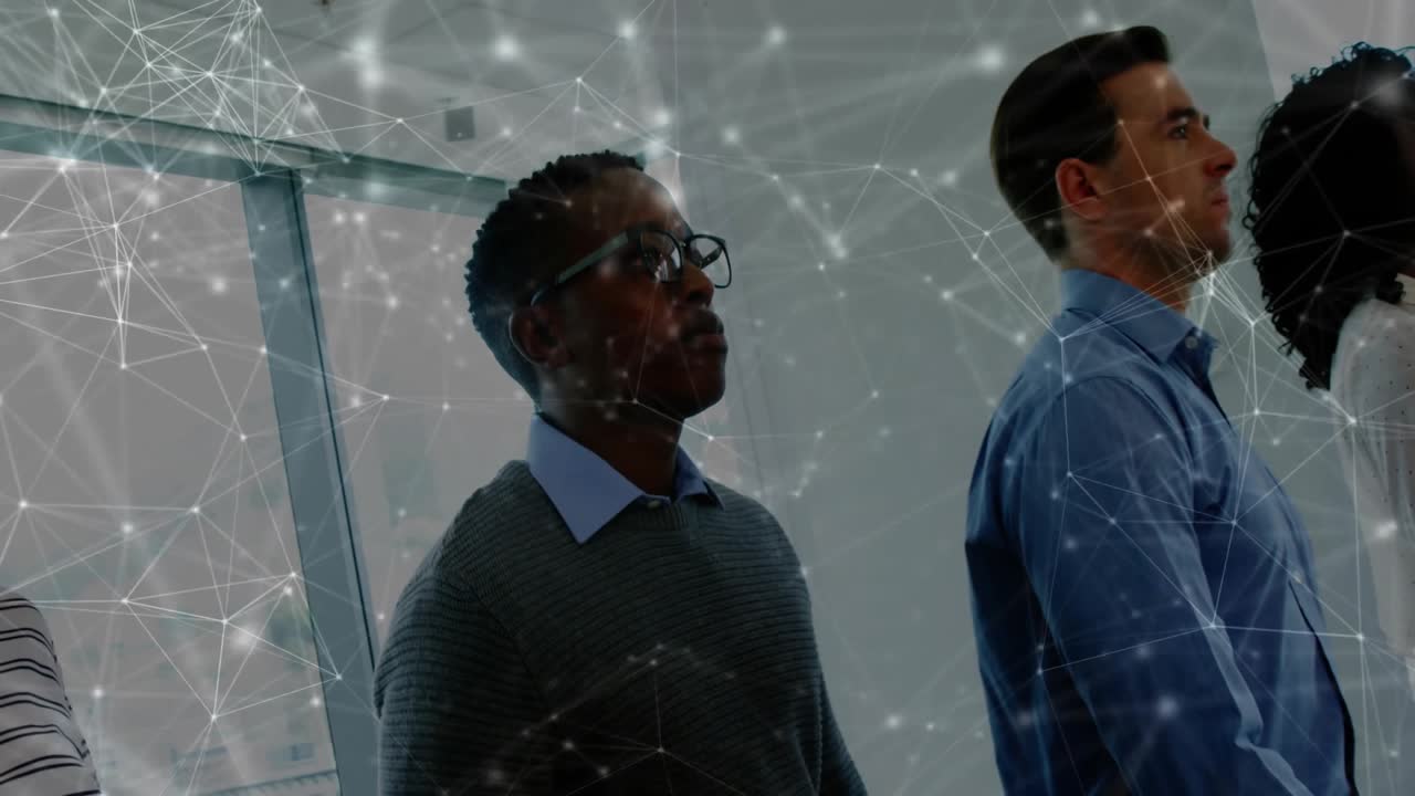 Camera panning across business team by window wall with network overlay revealing member on right