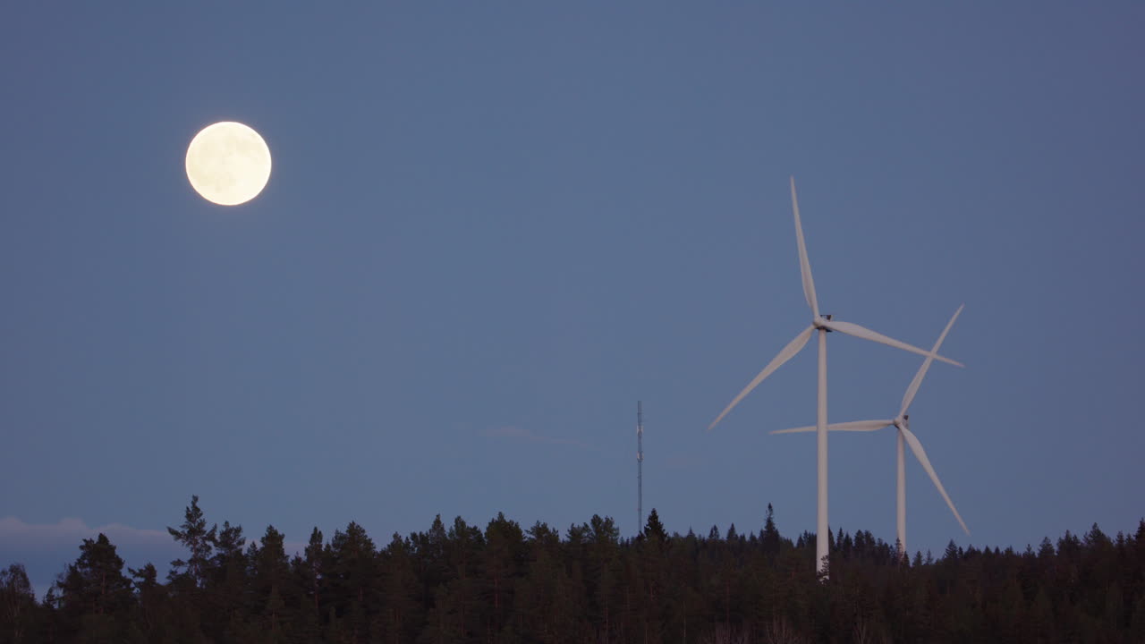 보름달, 슬로우 모션 - 떠오르는 보름달 옆에 풍력 터빈이 회전합니다.