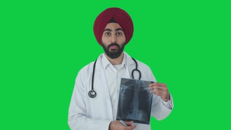 serious sikh indian doctor explaining x ray report to patient green screen