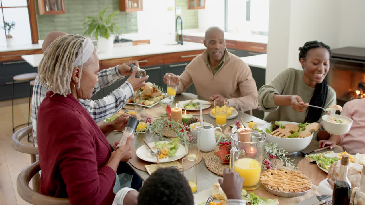 African american parents, children and grandparents celebrating at thanksgiving dinner, slow motion