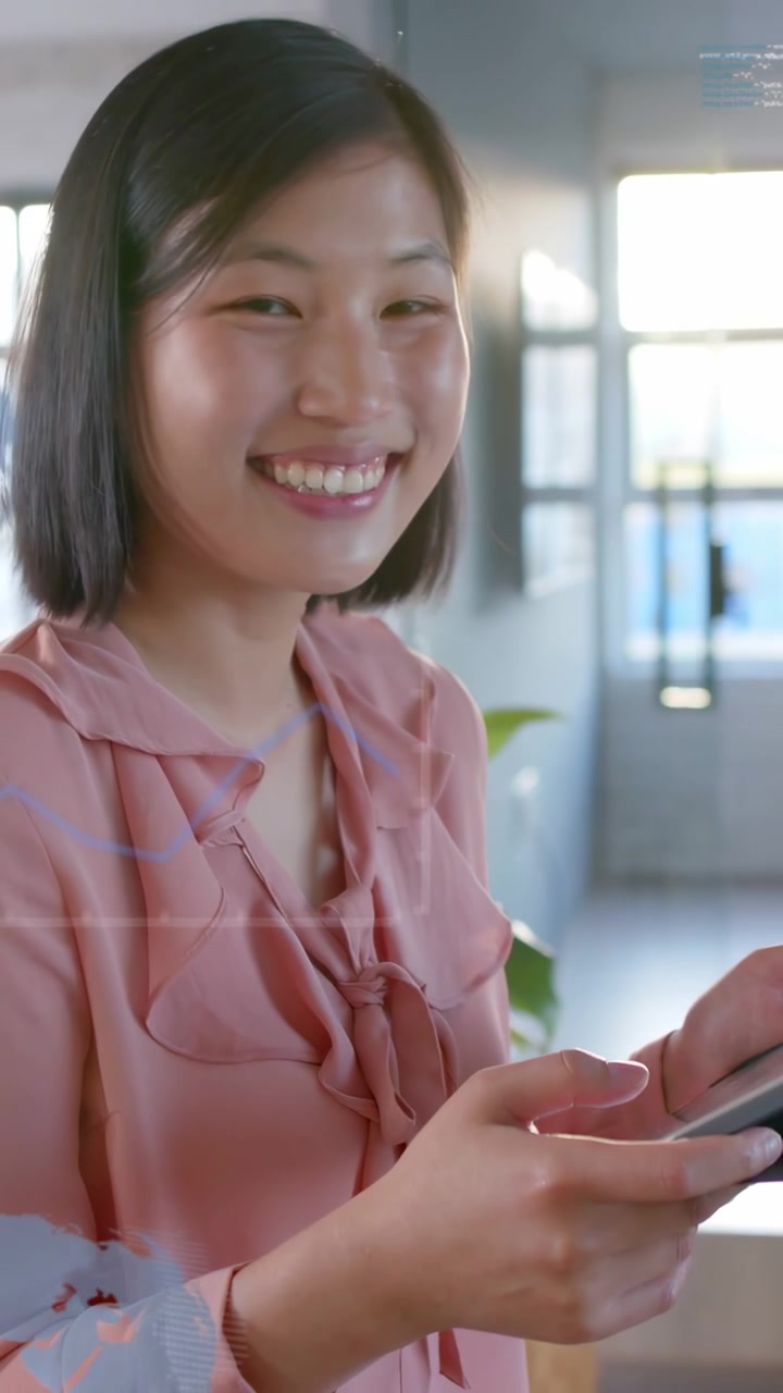 Video verticale: Donna che tocca lo schermo di un tablet in ufficio, avviando grafici aziendali animati da rivedere.