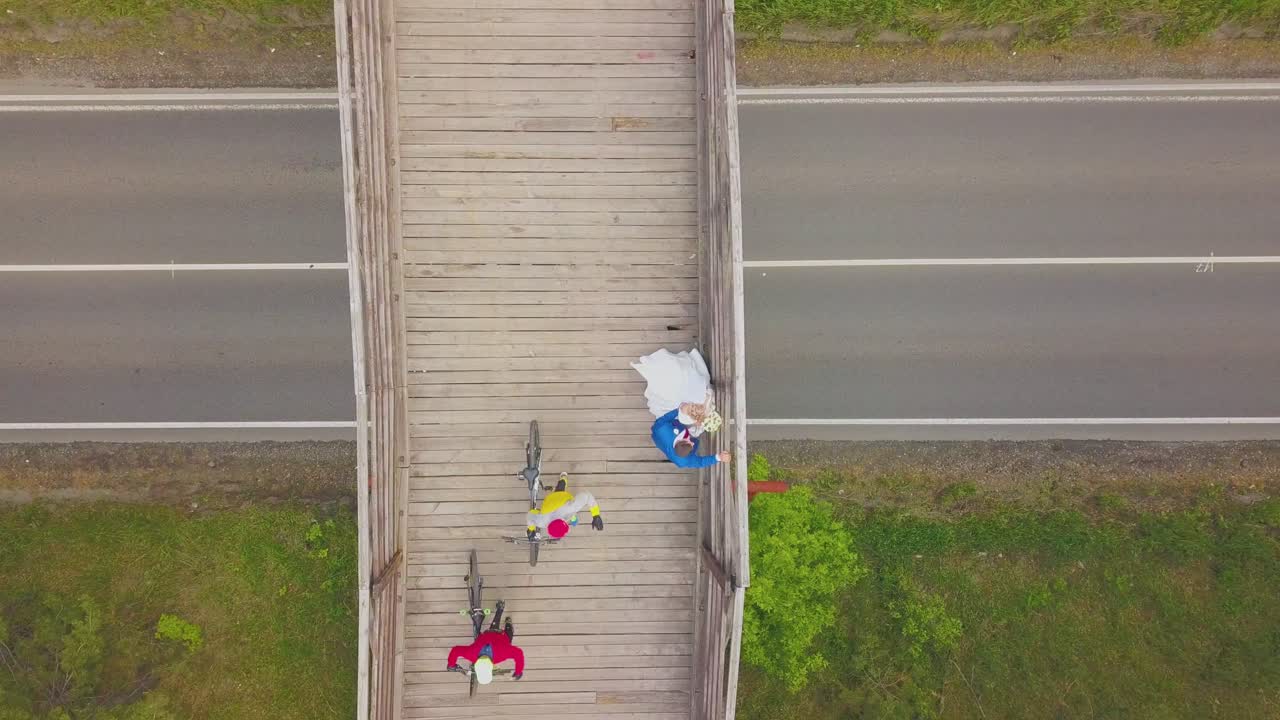 새로 결혼 한 부부 와 자전거 타는 사람 들 이  ⁇ 은 다리 위쪽 에서