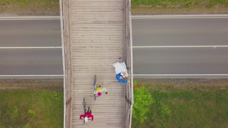 pareja de recién casados y ciclistas en la vista superior del puente estrecho