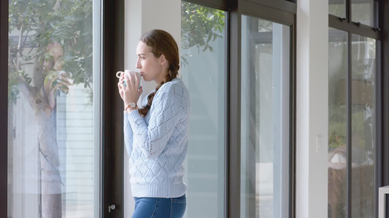 태양이 비치는 거실에서 커피 한 잔을 마시는 고민하는 백인 여성, 슬로우 모션