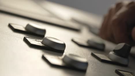 closeup of hands flicking switches and pushing buttons on industrial machine