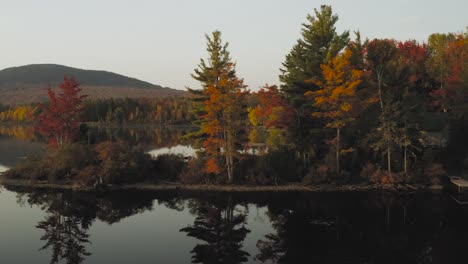 autumn reflections on a calm lake at sunrise aerial slide
