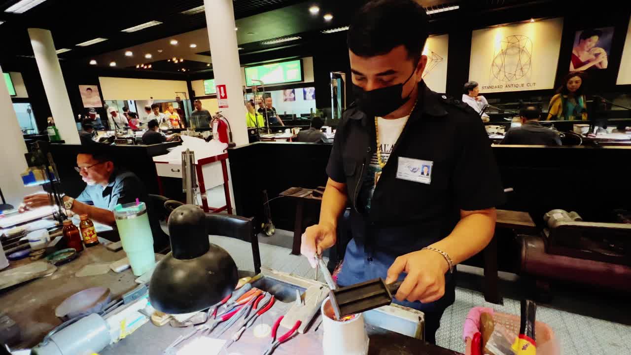 A smith peddling the burner and melting the gold in a workspace