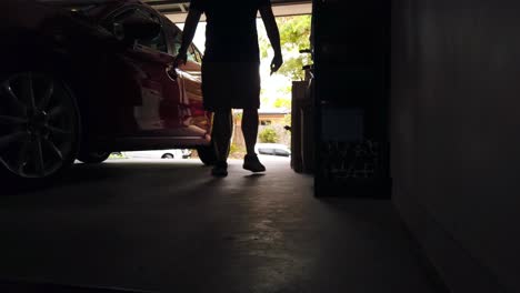 un tipo subiendo a un coche en el garaje.