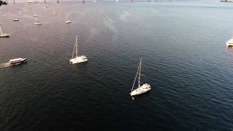 Boat-cruising-past-sailboats-in-Jamestown-Rhode-Island-bay