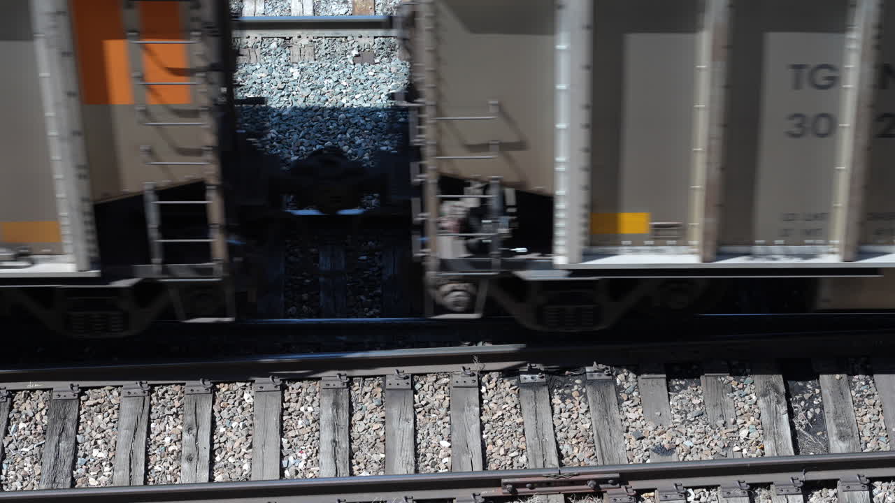 Rail freight transported in hopper cars on railway, top angle close-up