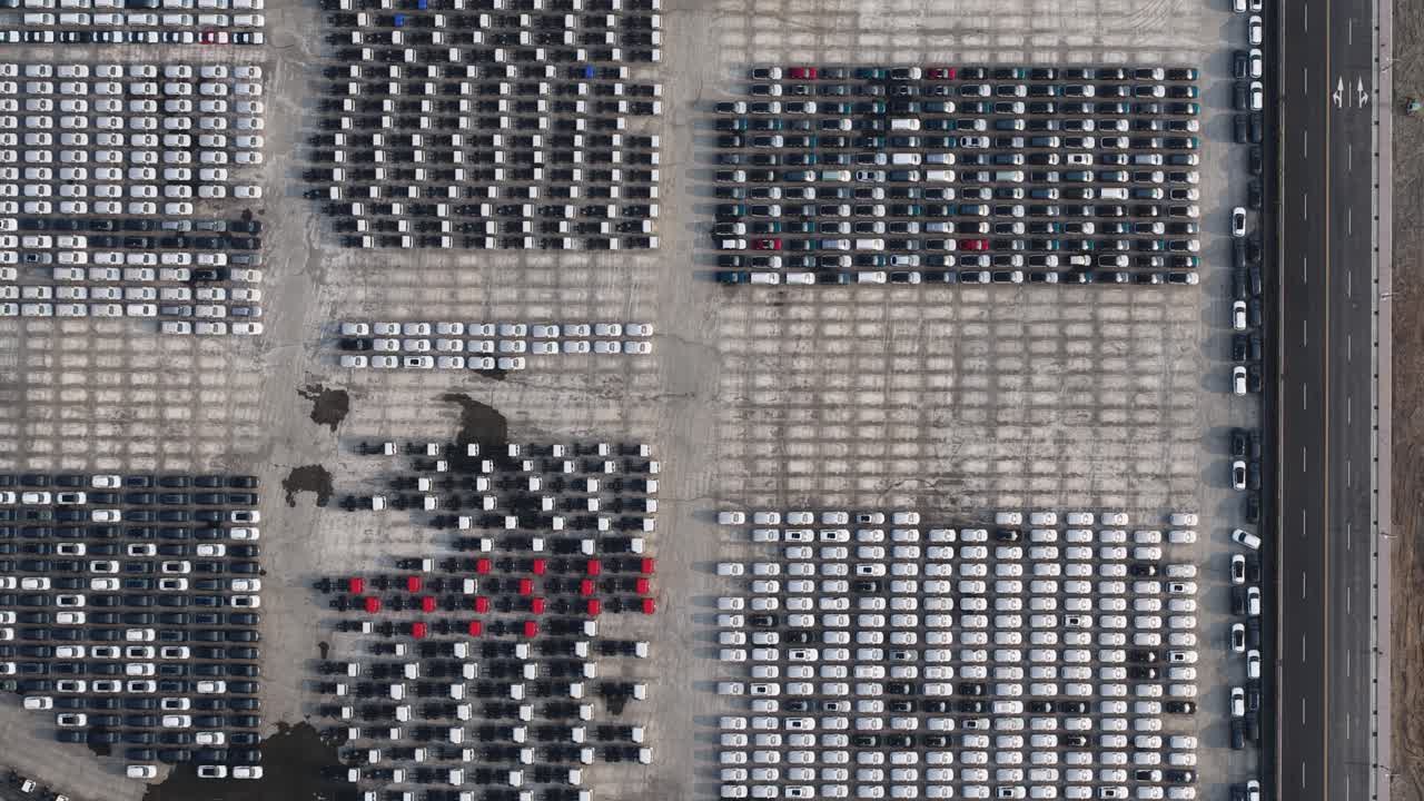 Aerial top down view of new cars parked at an automotive factory