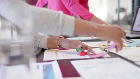 African-american-colleagues-with-documents-and-graphs-on-table-discussing-work,-slow-motion