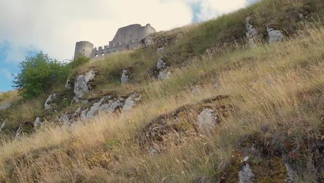 View-from-below-of-people-walking-toward-Rocca-Calascio-Ladyhawke-castle