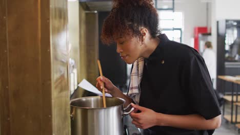 Mixed-race-female-chef-cooking-dish-in-a-pot