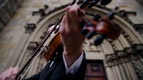 violinist performing outdoors near a church