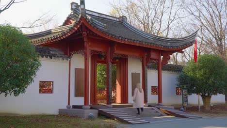 caucasian blond girl tourist enters the gate of korean temple in suncheon bay national garden