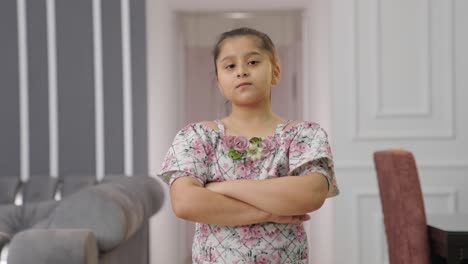 Confident-Indian-kid-girl-standing-crossed-hands