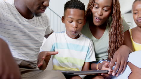 family enjoying time together, son showing something on tablet to father and mother