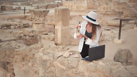 arqueólogo trabajando en un sitio de excavación con artefactos y una computadora portátil
