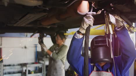 Video-Von-Zwei-Verschiedenen-Kfz-Mechanikerinnen,-Die-Ein-Auto-Schweißen