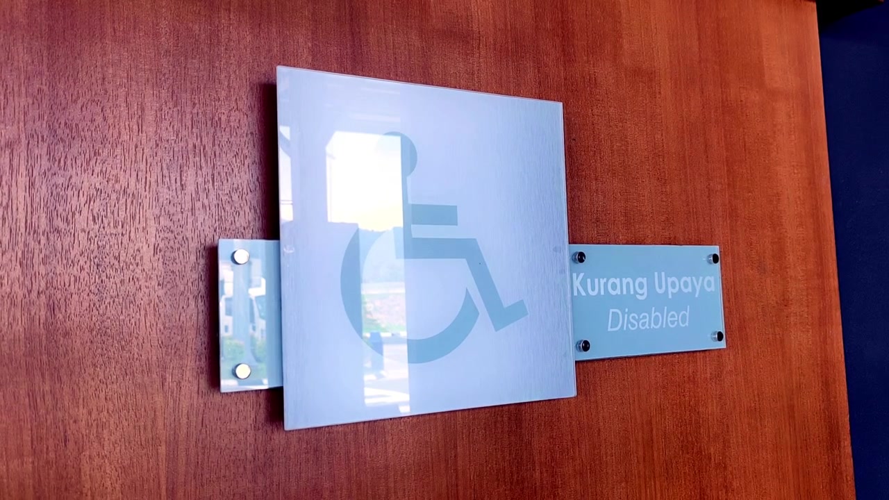A disabled accessible toilet sign is mounted securely on the wall. It provides clear visibility for everyone. The wheelchair symbol indicates an inclusive public facility.