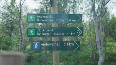 hiking trail sign in a forest at anderdalen national park, senja, norway