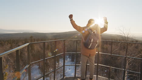man celebrating a summit view on a mountaintop