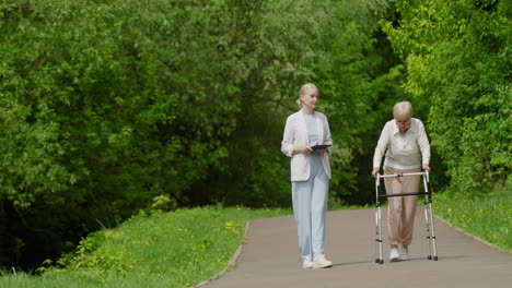 nurse assisting elderly woman in park