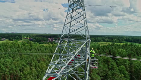 volando por torre de pilón de acero con liniero trabajando en una plataforma elevada