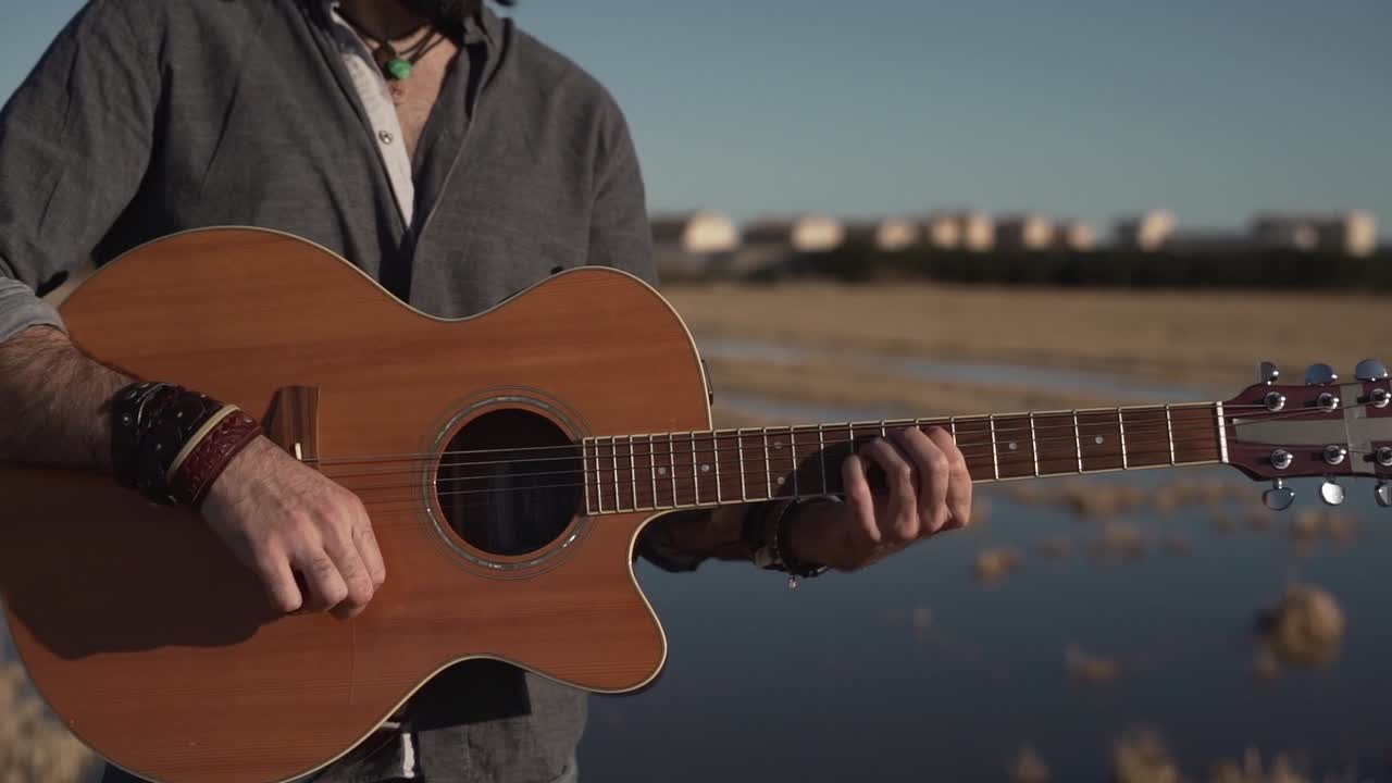 야외에서 어쿠스틱 기타를 연주하는 남자