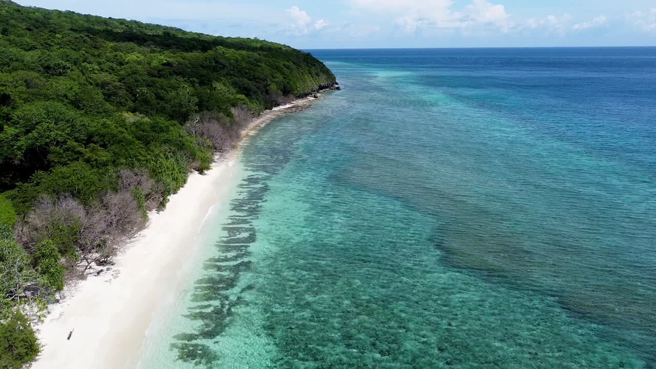 Aerial drone view flying over pristine white sand beach with turquoise crystal clear ocean water on tropical island of Timor-Leste, Southeast Asia