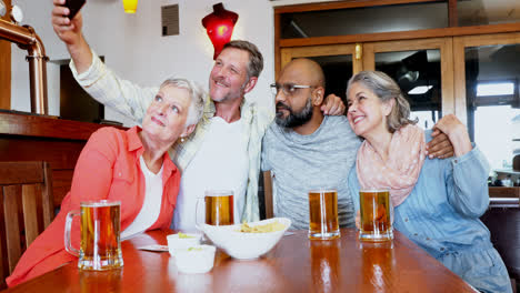 friends taking selfie with mobile phone in bar 4k