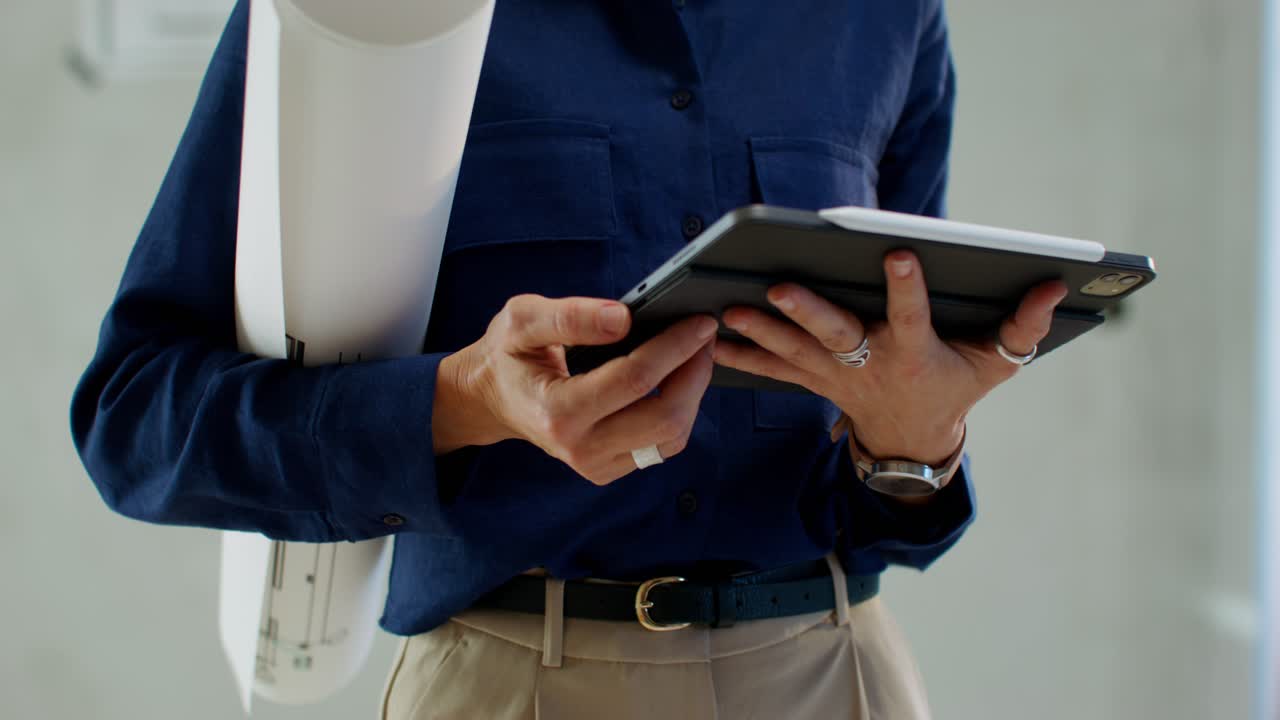 mujer arquitecta trabajando con planos y tableta