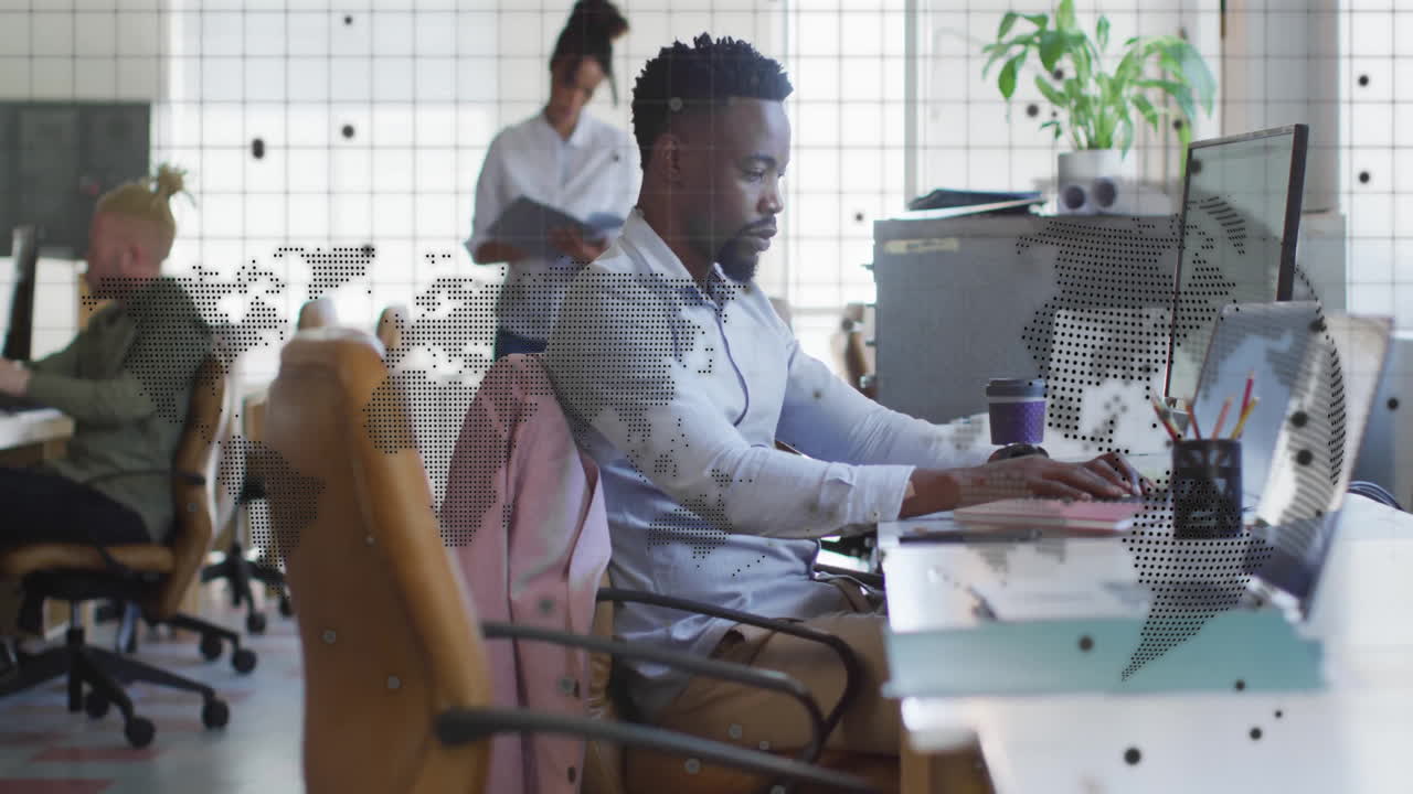 Man working at desk with world map animation overlay in modern office