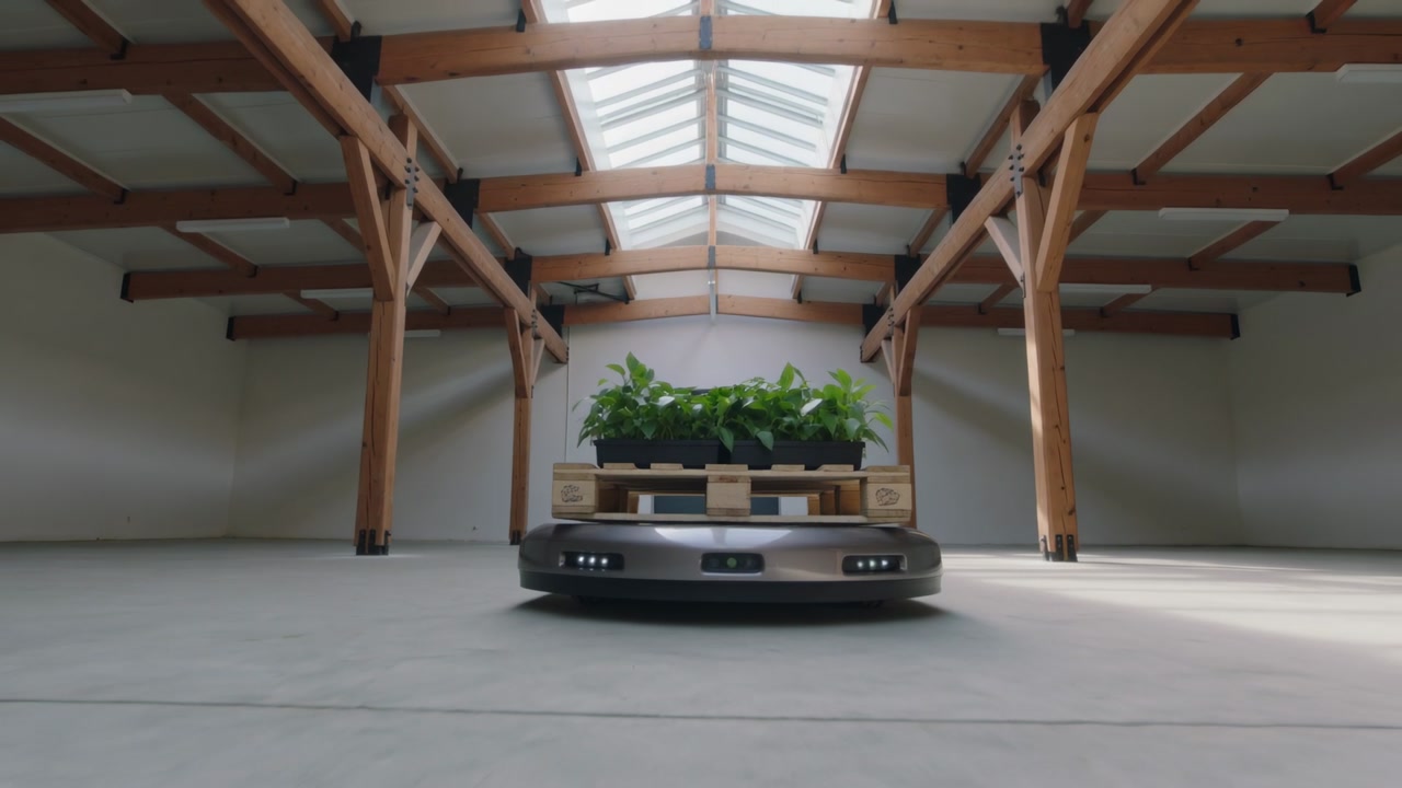 Starting robot carrying pallet of plants moving closer in hall for staging with front sensors