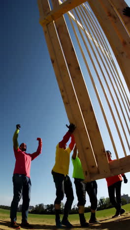 a team of people working together to lift and build a large wooden structure outdoors