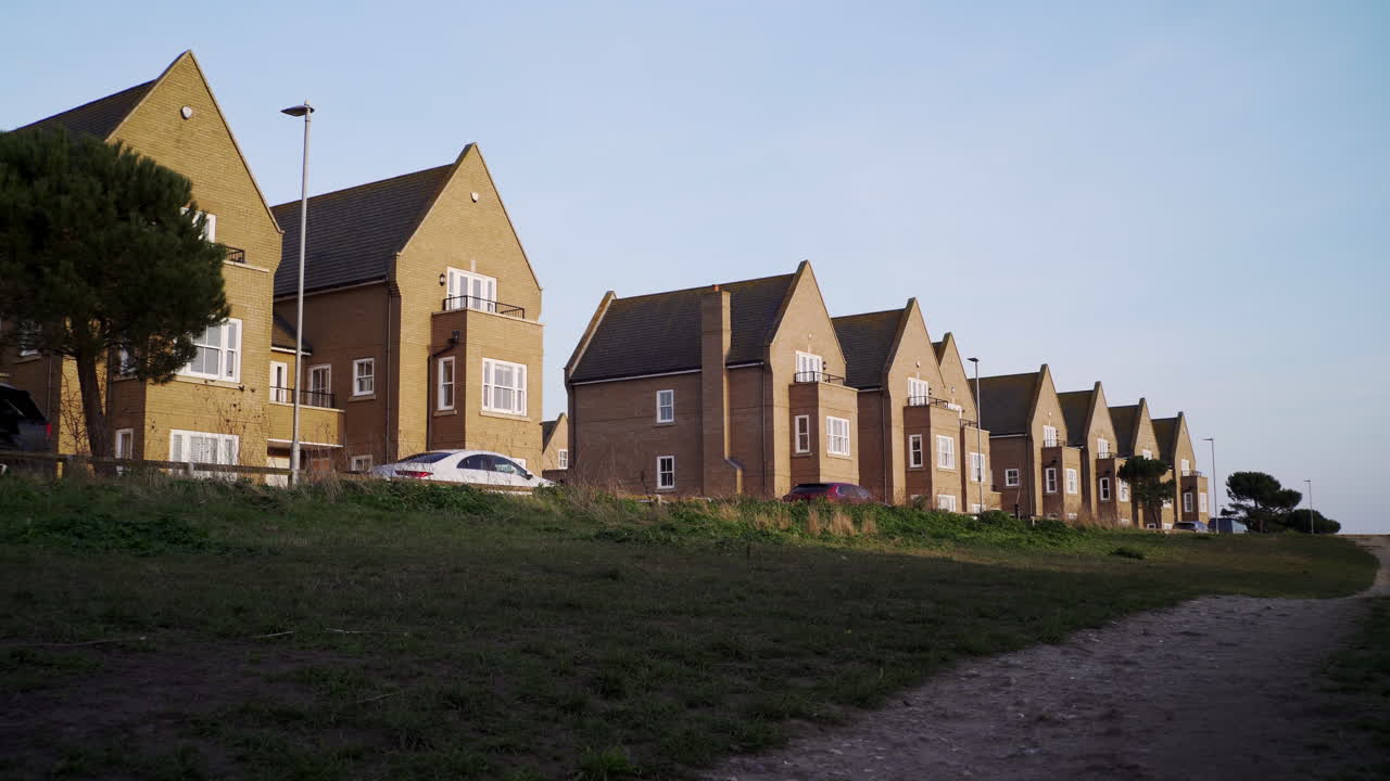 Row of detached new build houses on outskirts of town. Brick homes in countryside. Residential buildings