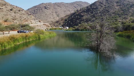 vista aérea de drones sobre el agua, acercándose a la presa oscura de wadi, en al baha, arabia saudita