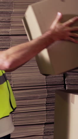 trabajador de almacén apilando cajas de cartón