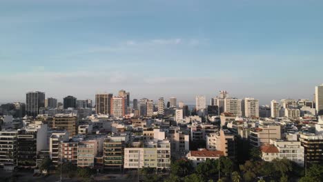 Aerial-reveal-of-the-Ipanema-neighbourhood-in-Rio-de-Janeiro-and-the-city-lake-with-high-rise-and-low-rise-buildings-at-sunrise