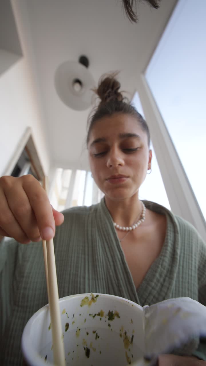 Woman eating noodles with chopsticks