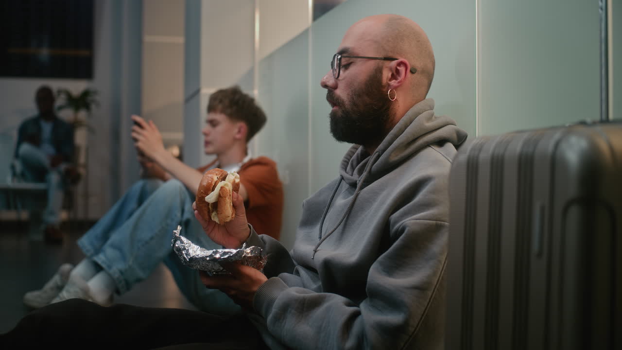 Passengers Waiting in Airport Lounge Eating